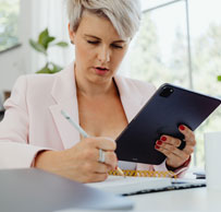 Mujer profesional con tablet escribiendo notas en oficina luminosa, gestión administrativa o planificación empresarial
