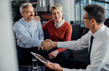 Pareja madura estrechando la mano con asesor profesional en oficina, acuerdo de seguros o asesoría financiera