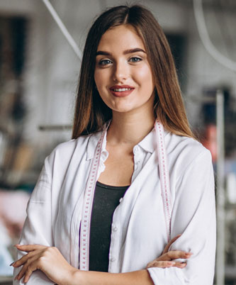 Mujer joven con cinta métrica en el cuello sonriendo en taller de costura, emprendedora en negocio textil o artesanal