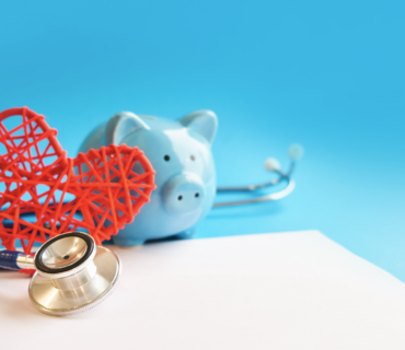 Hucha con estetoscopio aislada sobre fondo azul.