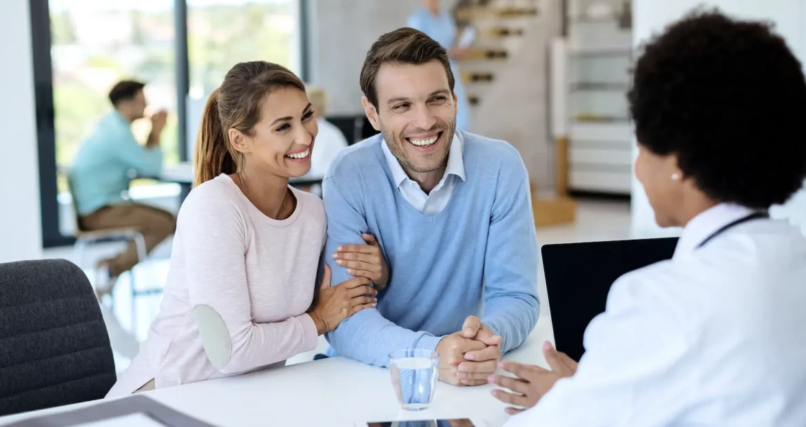 Una pareja feliz en consulta con un médico en una clínica.