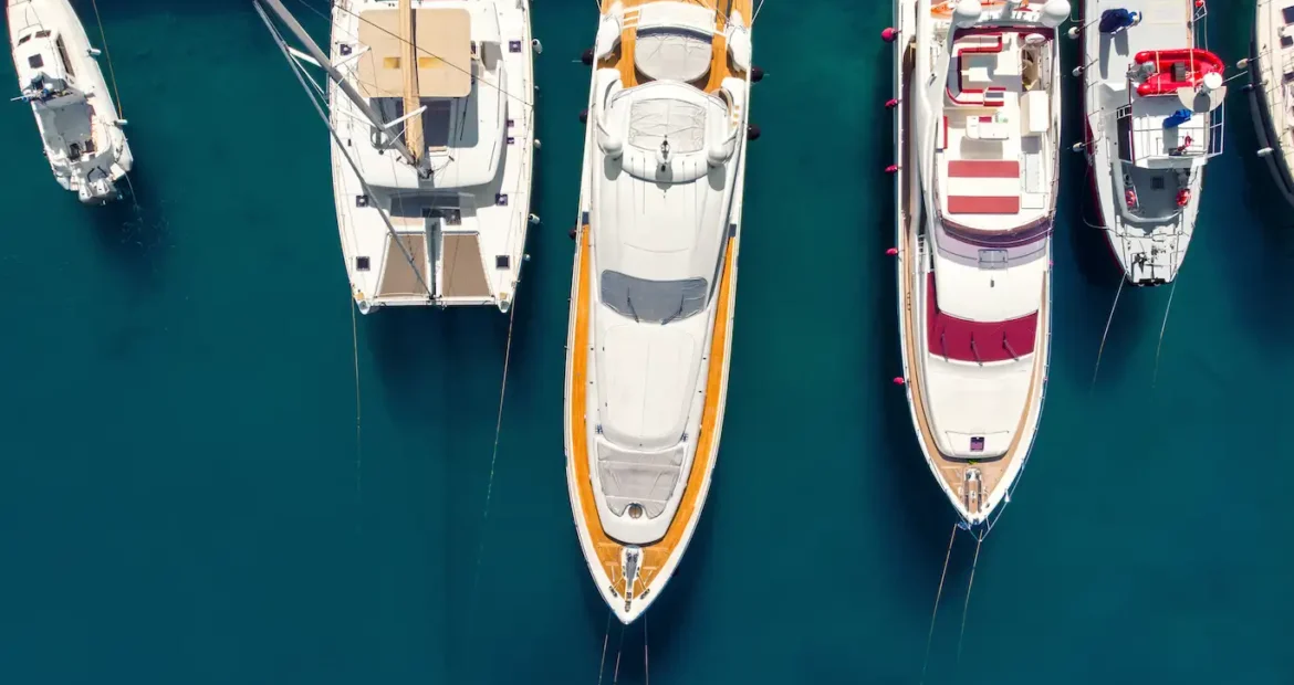 Panorámica aérea de numerosos yates y barcos amarrados en la costa de una bahía croata, con aguas cristalinas de color azul turquesa