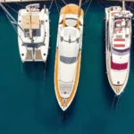 Panorámica aérea de numerosos yates y barcos amarrados en la costa de una bahía croata, con aguas cristalinas de color azul turquesa