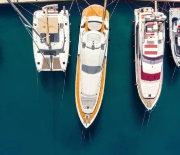 Panorámica aérea de numerosos yates y barcos amarrados en la costa de una bahía croata, con aguas cristalinas de color azul turquesa
